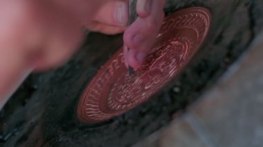 Buhara ustası kalıpları tepsiye oyuyor. Yaklaşın, ağır çekim.