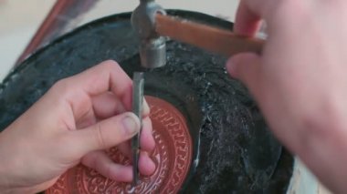 Buhara ustası kalıpları tepsiye oyuyor. Yaklaşın, ağır çekim.