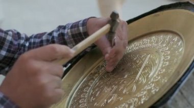 Buhara ustası kalıpları tepsiye oyuyor. Yaklaşın, ağır çekim.