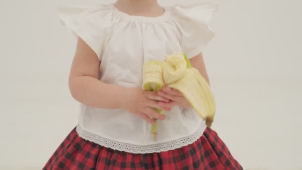 Ekose Bantlı Etekli Küçük Kız Büyük Bir Muz Yiyor Ağır — Stok video