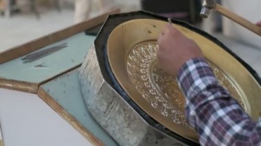Buhara ustası kalıpları tepsiye oyuyor. Yavaş çekim