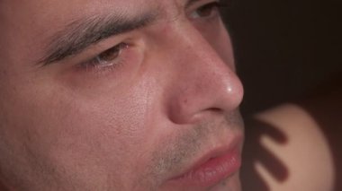 Genç kaslı esmer adam alkol içiyor. Portre yakın çekim, ağır çekim.