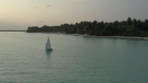モルディブの熱帯の島々の近くに停泊穏やかな海に帆を上げる小さな帆船 ドローン航空 — ストック動画