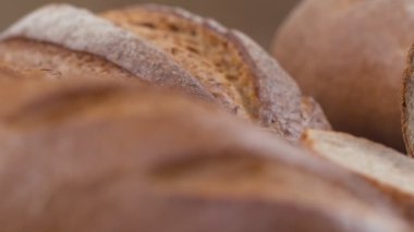 Taze pişmiş tahıllı ekmeğin yakın çekimi yavaş çekimde hareket eder..