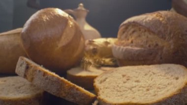 Taze pişmiş tahıllı ekmeği seramik kil sürahinin arka planına yakın çekim yavaş çekimde hareket ettir..