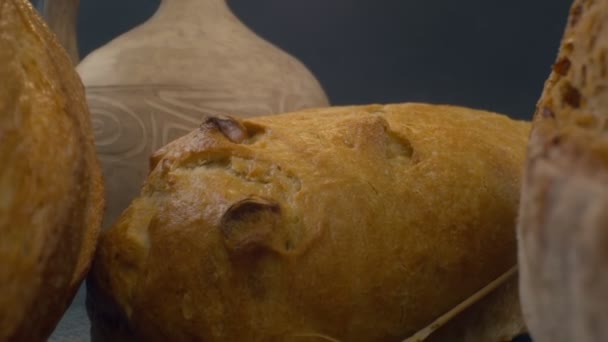陶瓷陶瓷壶慢动作背景下新鲜烘烤的全麦面包的特写 — 图库视频影像
