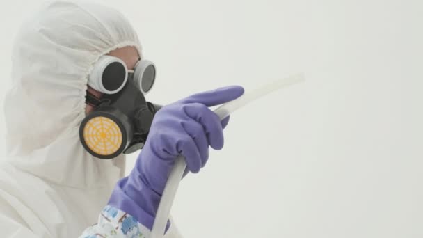身穿白色化学防护服 戴着防毒面具的人 使用的是由玻璃罐和塑料管制成的奇怪的烟雾机 动作缓慢 — 图库视频影像