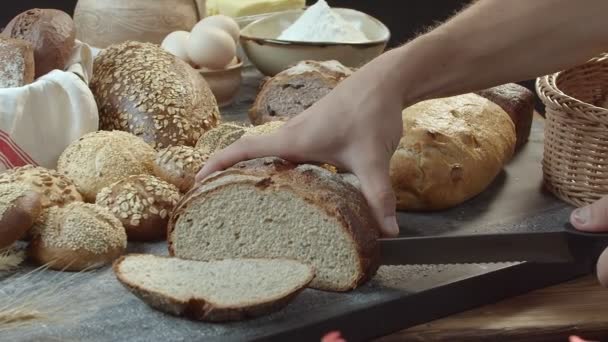건포도 참깨나 땅콩등 빵들로 위에서 신선하게 네덜란드 자르고 측면에 바구니 — 비디오