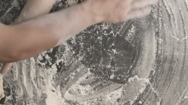 Erkek eller ahşap bir tahta üzerinde merdane kullanarak hamuru rulo haline getirirler. Bir sonraki rulo için hazırlanma alanından ziyade un serpiştirirler. Erkek eller, tahta bir raptiye ile hamuru yuvarlarlar.