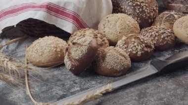 Ahşap masada farklı türde taze Hollanda ekmeği var. Kamera ileri geri hareket ediyor.