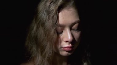 Uzun açık kahverengi saçlı, gri gözlü, beyaz bardaktan zevk alarak kahve içen bir kızın yakın çekimi. Siyah bir arkaplanda tam yüz olarak çekilen