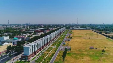 İnsansız hava aracı hareket halindeki arabalarla şehrin yollarında ve otoyollarında uçuyor. Bulutlu bir yaz günü. Hava Görünümü.