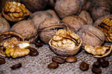 Ceviz bütün, doğranmış ve kavrulmuş kahve taneleri jüt arka planda yatar. Beslenmede yararlı bir protein ve yağ kaynağı.