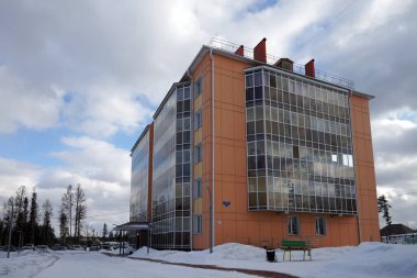 Krasnoyarsk Bölgesi 'nin Taezhny köyündeki yeni tuğladan apartman binalarının yakınındaki avluda dinlenmek için bir bank duruyor. Rusya.