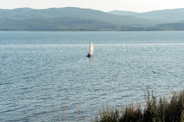 Надувная Лодка Парусом Плавает Поверхности Воды Озера Фоне Лесистых Гор — стоковое фото