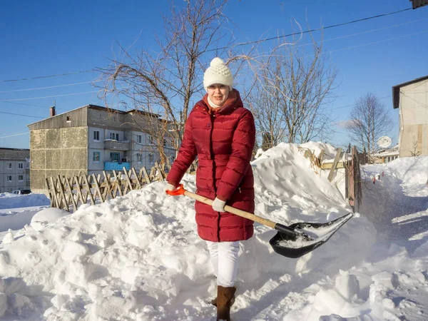 Een Jonge Vrouw Reinigt Een Pad Van Sneeuw Met Een — Stockfoto