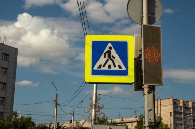 Trafik işaretleri bir yaz günü gökyüzü ve şehir binalarının arka planındaki trafik ışığının yanındaki direğe asılır..