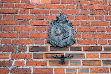 Peter the Great old bronze bas-relief on the brick wall of the Cathedral clipart