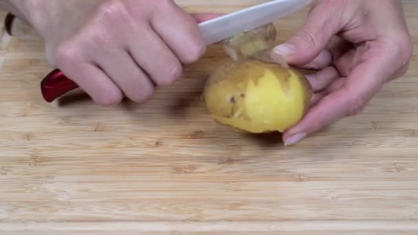 Mujer pela patatas hervidas en la cocina para una ensalada rusa olivier — Vídeo de stock