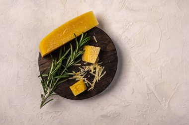 Kesme tahtasında biberiye dalı ve parmesan peyniri