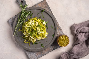 Makarnayı pesto, stracciatella peyniri ve maydanozla kapat.