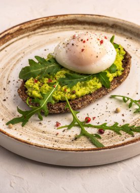 Avokado, tuzlu somon, roka ve çavdar ekmekli haşlanmış yumurta tostu.