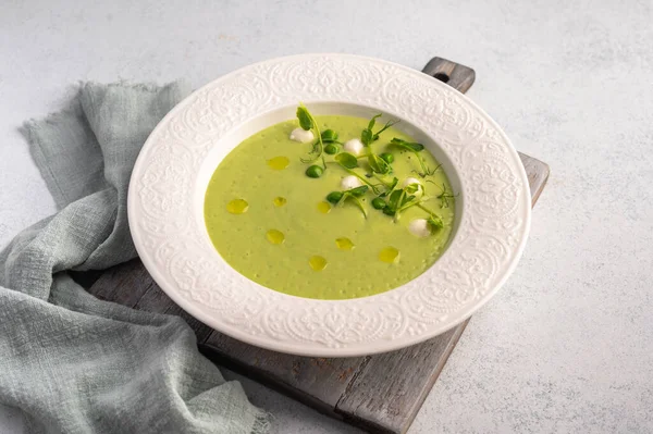 Homemade soup puree of green peas, coconut milk with mini mozzarella cheese