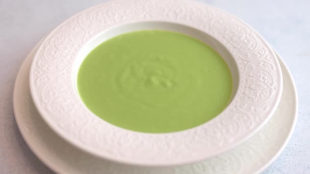 女性の手は緑のエンドウ豆の純粋なキャラメルチュイルメッシュ自家製スープを飾る — ストック動画