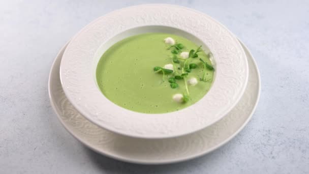 Femme main orne brins de verdure soupe maison purée de pois verts — Video