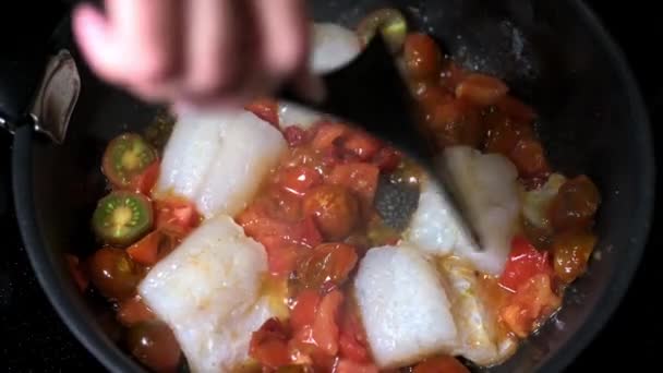 Kadınların elleri geleneksel Sicilya balığıyla domatesli spatulayla karıştırılır. — Stok video