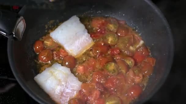 Γυναικείο χέρι απλώνει φρέσκα κομμάτια παραδοσιακού σικελικού ψαριού με ντομάτες — Αρχείο Βίντεο