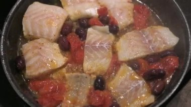 Kızartma tavasında pişirilmiş beyaz balık, domates ve zeytin.