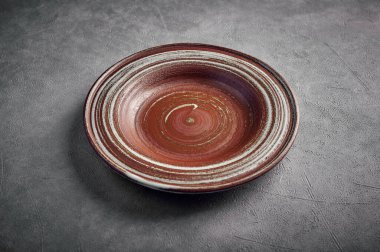 Koyu arkaplanda boş seramik kahverengi plaka