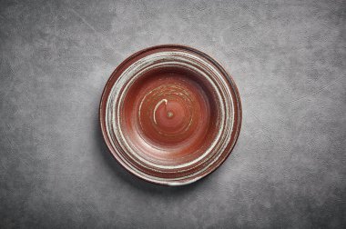 Koyu arkaplanda boş seramik kahverengi plaka