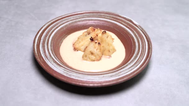 Γυναικείο χέρι πασπαλίζουμε ψητά καρύδια ψημένα σπιτικό κουνουπίδι στο πιάτο με σάλτσα γραβιέρα — Αρχείο Βίντεο