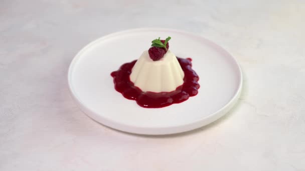 Femme main saupoudrée de pistaches concassées panna cotta à la framboise et à la menthe — Video