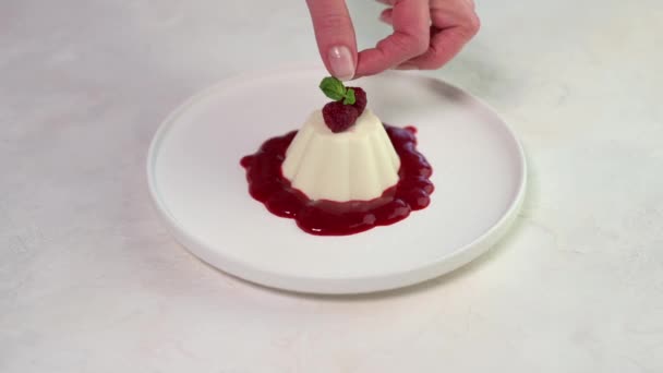 Ženská ruka klade mátový list na panna cotta — Stock video