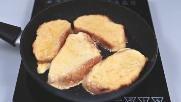Γυναίκα τηγανίζει σε τηγάνι και ανασηκώνει με πιρούνι Ισπανικές τορίγιες — Αρχείο Βίντεο