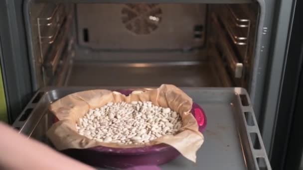 Kvinna lägger en bakplåt med rå quiche paj i ugnen — Stockvideo