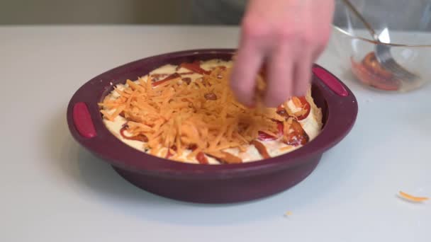 Frau bestreut geriebenen Cheddar-Käse mit einem Rohling für hausgemachte Kuchen-Quiche — Stockvideo