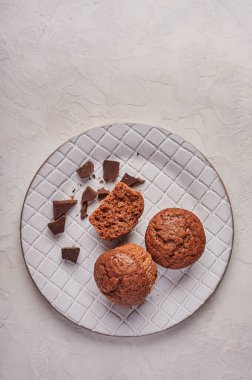 Ev yapımı çikolatalı kekler ve desenli tabakta çikolata parçaları.