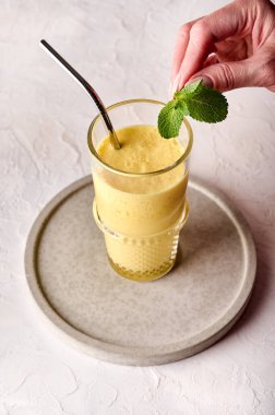 Kadın eli, lazanya içeceği üzerine nane şekeri tutuyor.