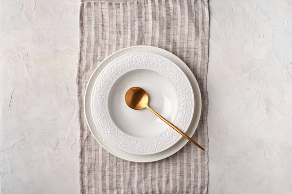 Порожня біла тарілка і золота ложка — стокове фото
