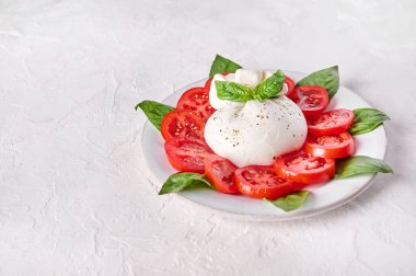 Geleneksel İtalyan burrata peyniri, fesleğen ve domates.
