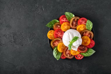 Geleneksel İtalyan burrata peyniri, fesleğen ve domates.