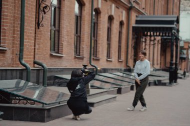 Genç bayan fotoğrafçı kız arkadaşıyla sokakta geziniyor. Gezginler şehirde yürürler. Şehre bak..