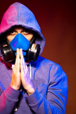 Bilinmeyen bir adamın portresi, karanlık arka planda neon maske takan bir hacker. Neon ışıklandırması yakınında silah tutan çift ırklı siber punk oyuncusunun seçici odak noktası