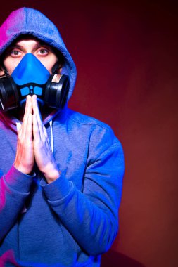 Bilinmeyen bir adamın portresi, karanlık arka planda neon maske takan bir hacker. Neon ışıklandırması yakınında silah tutan çift ırklı siber punk oyuncusunun seçici odak noktası