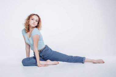 Alıştırma öncesi ısınma egzersizi yapan çekici zinde bir genç kız. Sağlıklı yaşam tarzı konsepti. Evde yoga yapan bir kadın. Kişisel izolasyon yararlı, eğlenceli ve eğitimlidir.