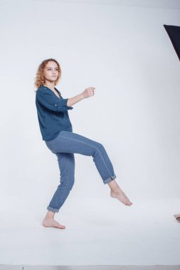 Stüdyoda dans eden komik Avrupalı kıvırcık saçlı kız. Neşeli moda atlayan hippi kız portresi